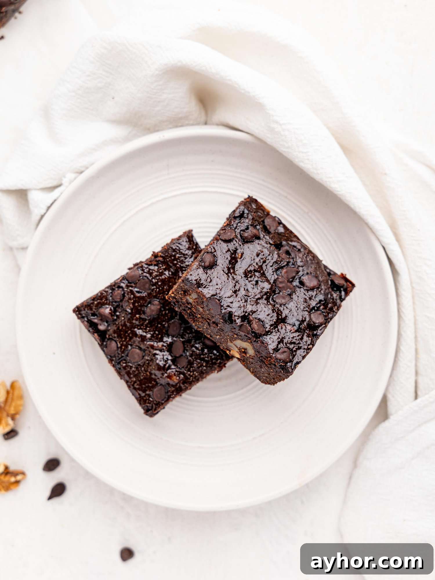 Bird's eye view of two cottage cheese brownies on a white plate.