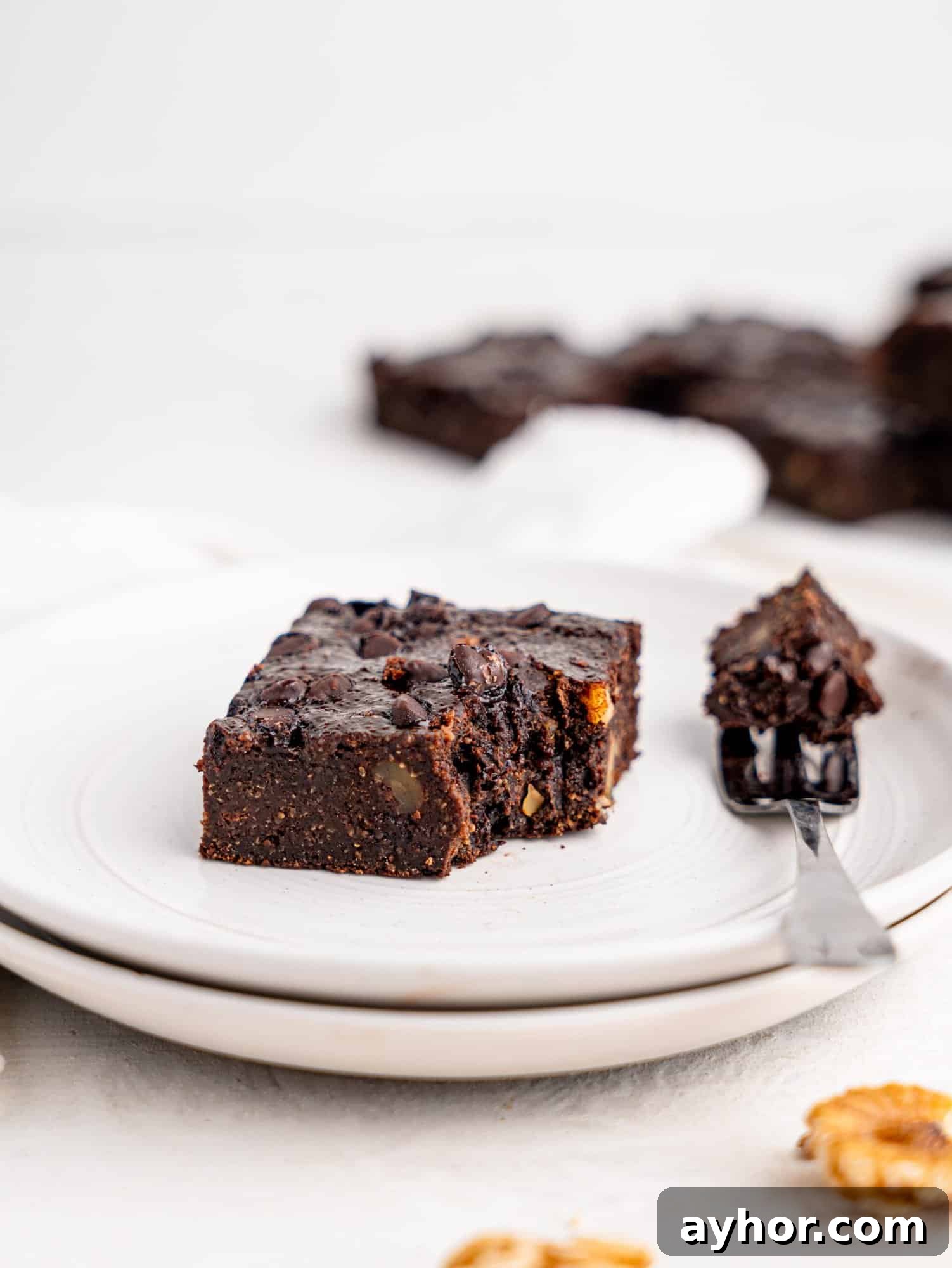 A half-eaten cottage cheese brownie on a white plate.