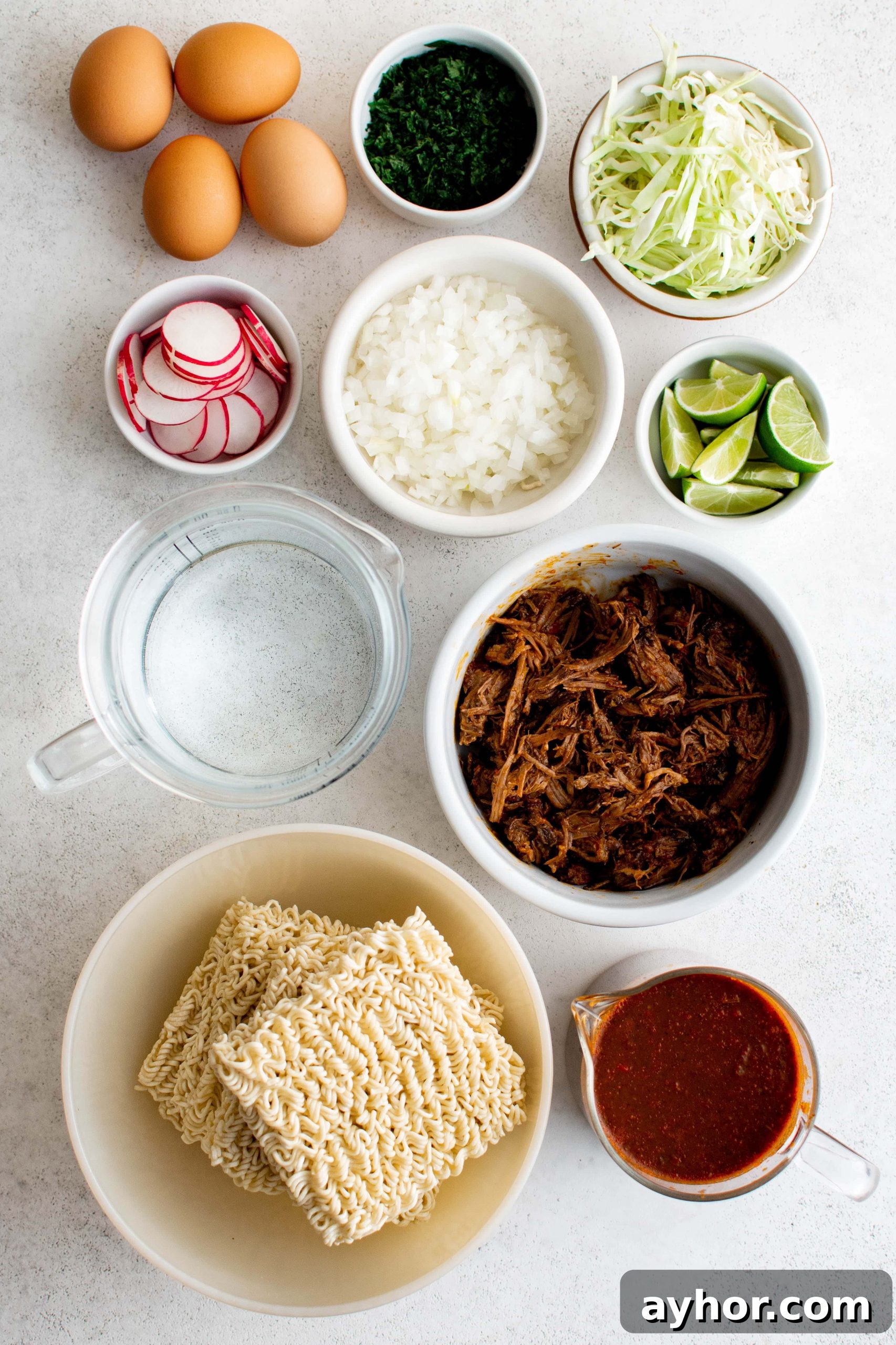 Birria Ramen Recipe: Flavorful Mexican-Style Beef Ramen 4 Ingredients needed to make birria ramen set aside in individual serving bowls.