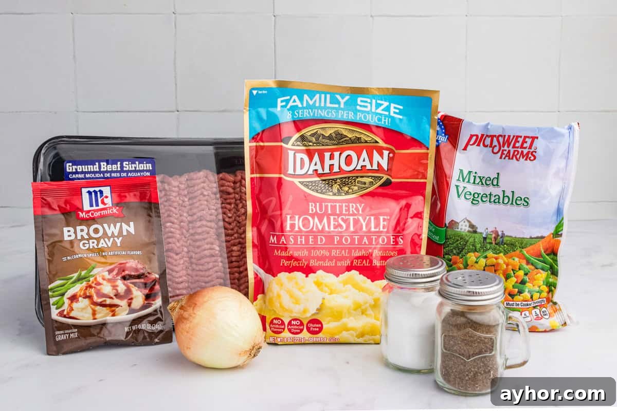 A neatly arranged selection of cottage pie ingredients, featuring a package of ground beef sirloin, McCormick brown gravy mix, Idahoan buttery mashed potatoes, a bag of frozen mixed vegetables, a whole onion, and two glass shakers of salt and pepper.