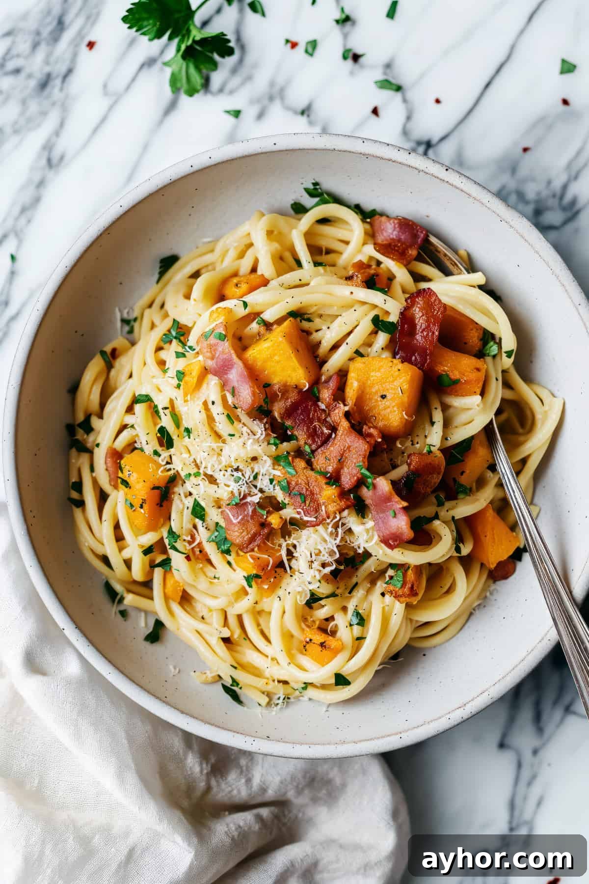 Pumpkin carbonara spaghetti with bacon and herbs.