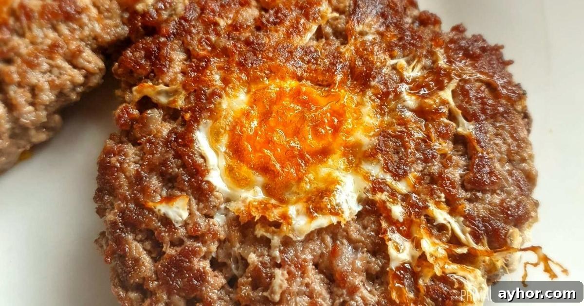 A plate of meat burgers with an egg on top.