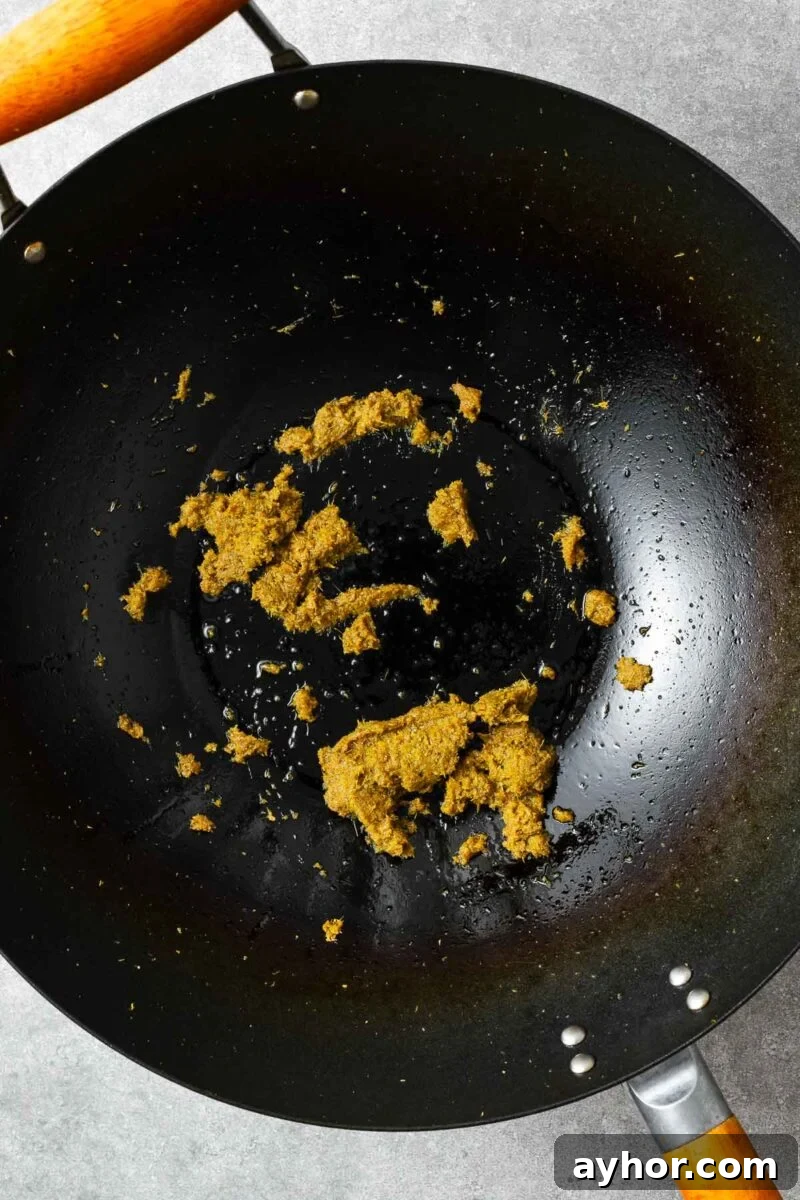 Frying green curry paste in oil.