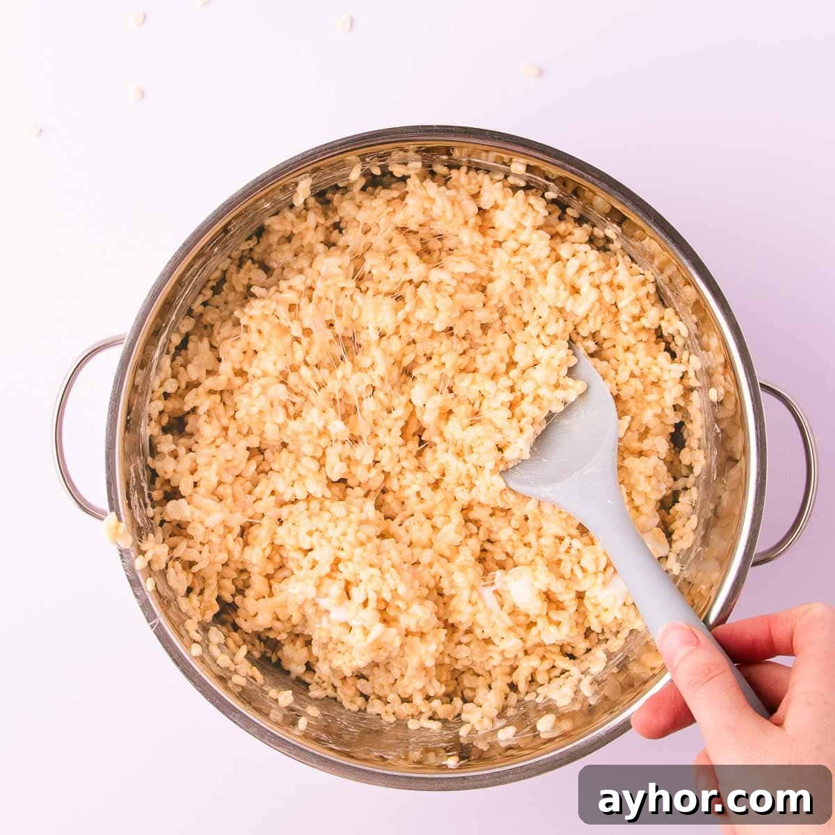 Gluten-Free Rice Krispie Treats Recipe That Really Crisps 7 The rice crispy cereal being stirred into the sticky marshmallow mixture.