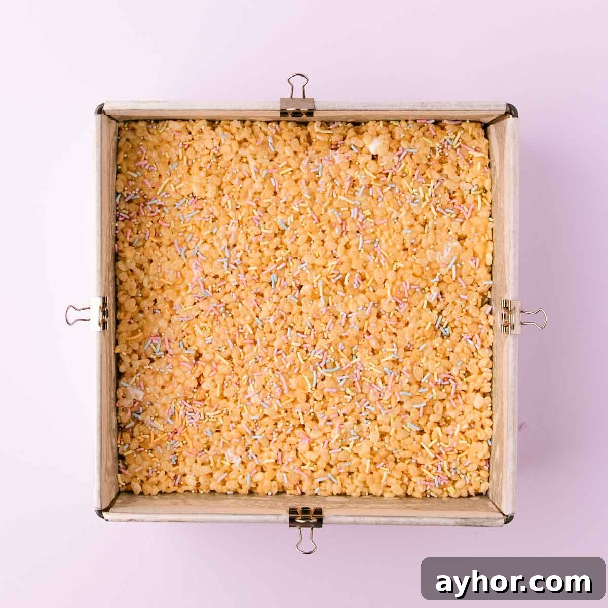 Gluten-Free Rice Krispie Treats Recipe That Really Crisps 9 The GF rice krispie treat mixture pressed into an even layer in the square pan, and sprinkled with pastel sprinkles.