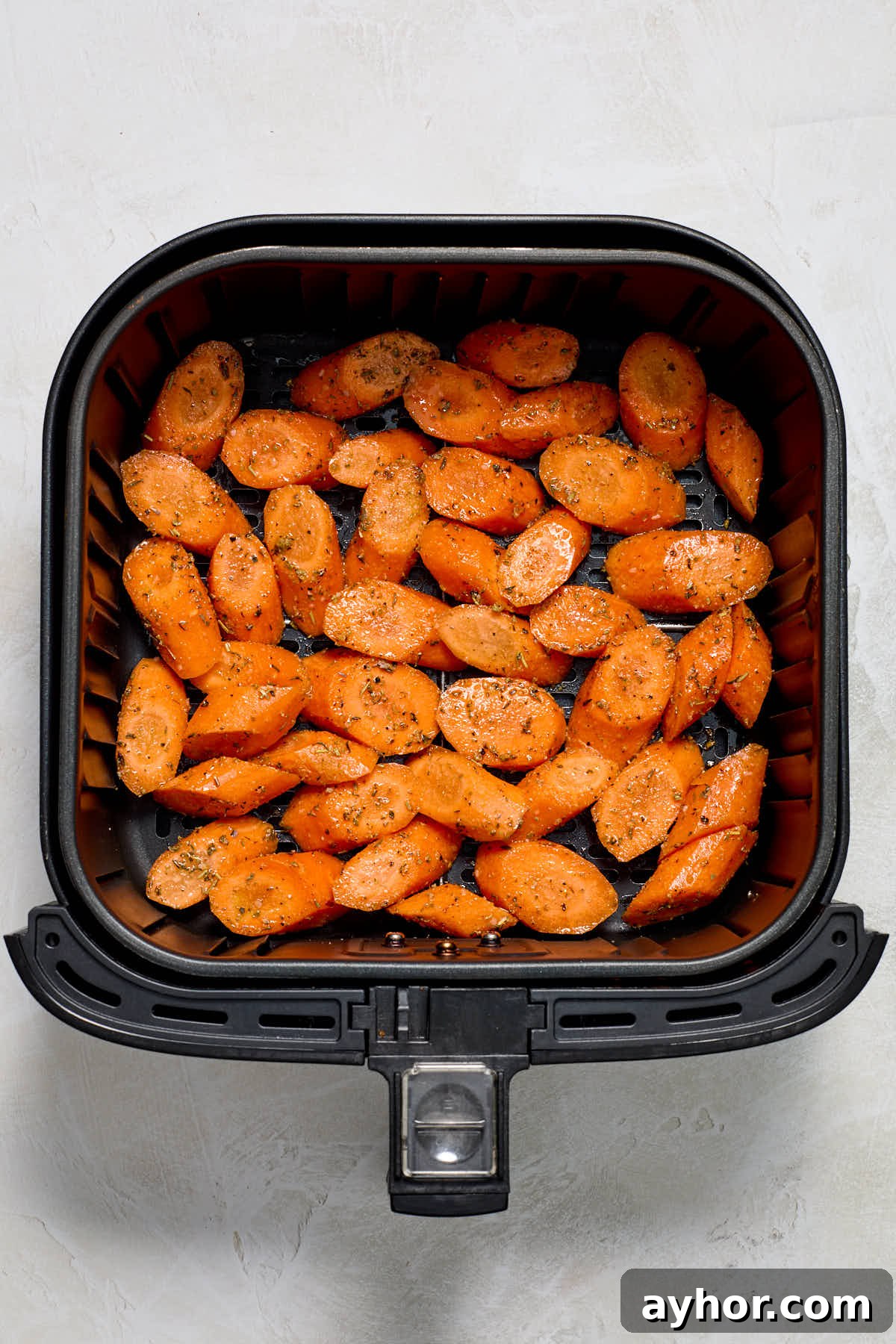 Carrots arranged in single layer in air fryer basket.