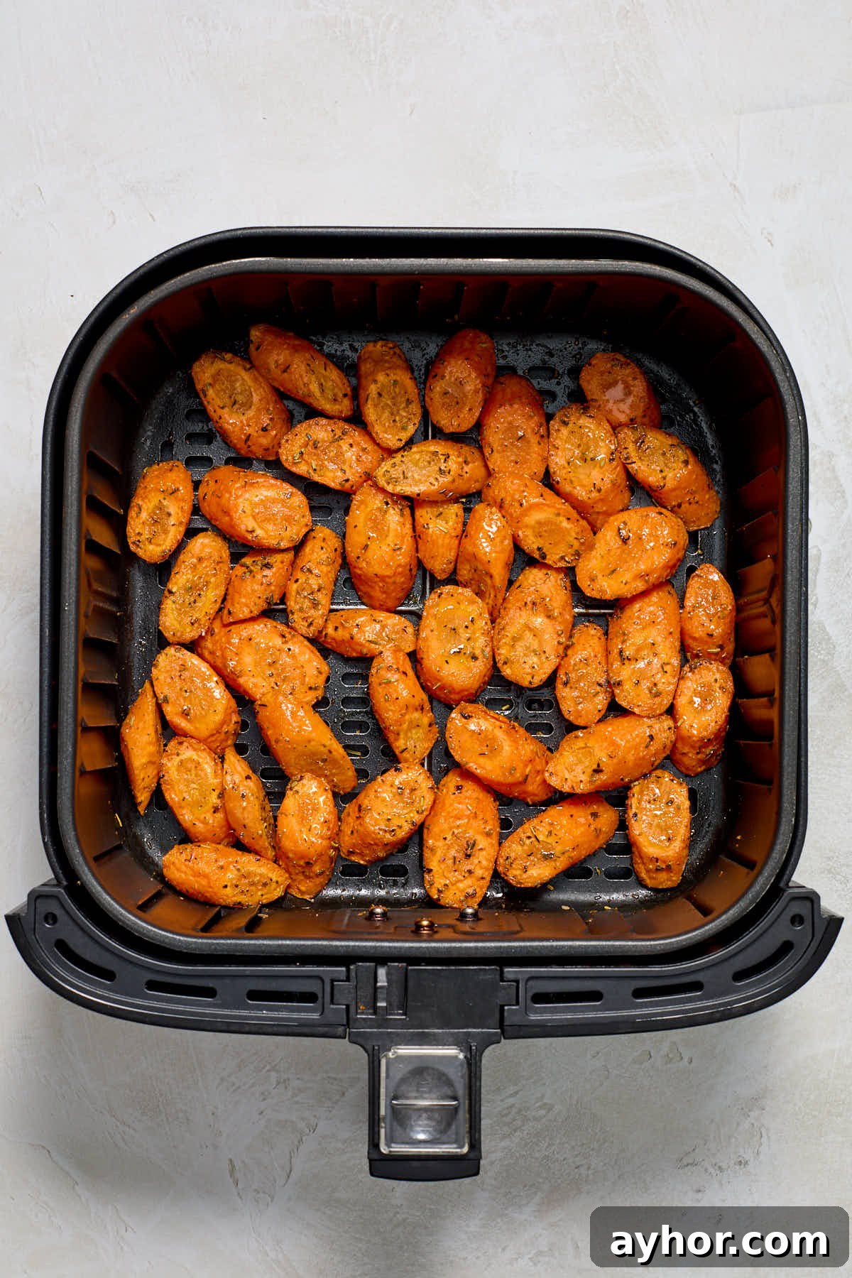 Air fried carrots in air fryer basket.