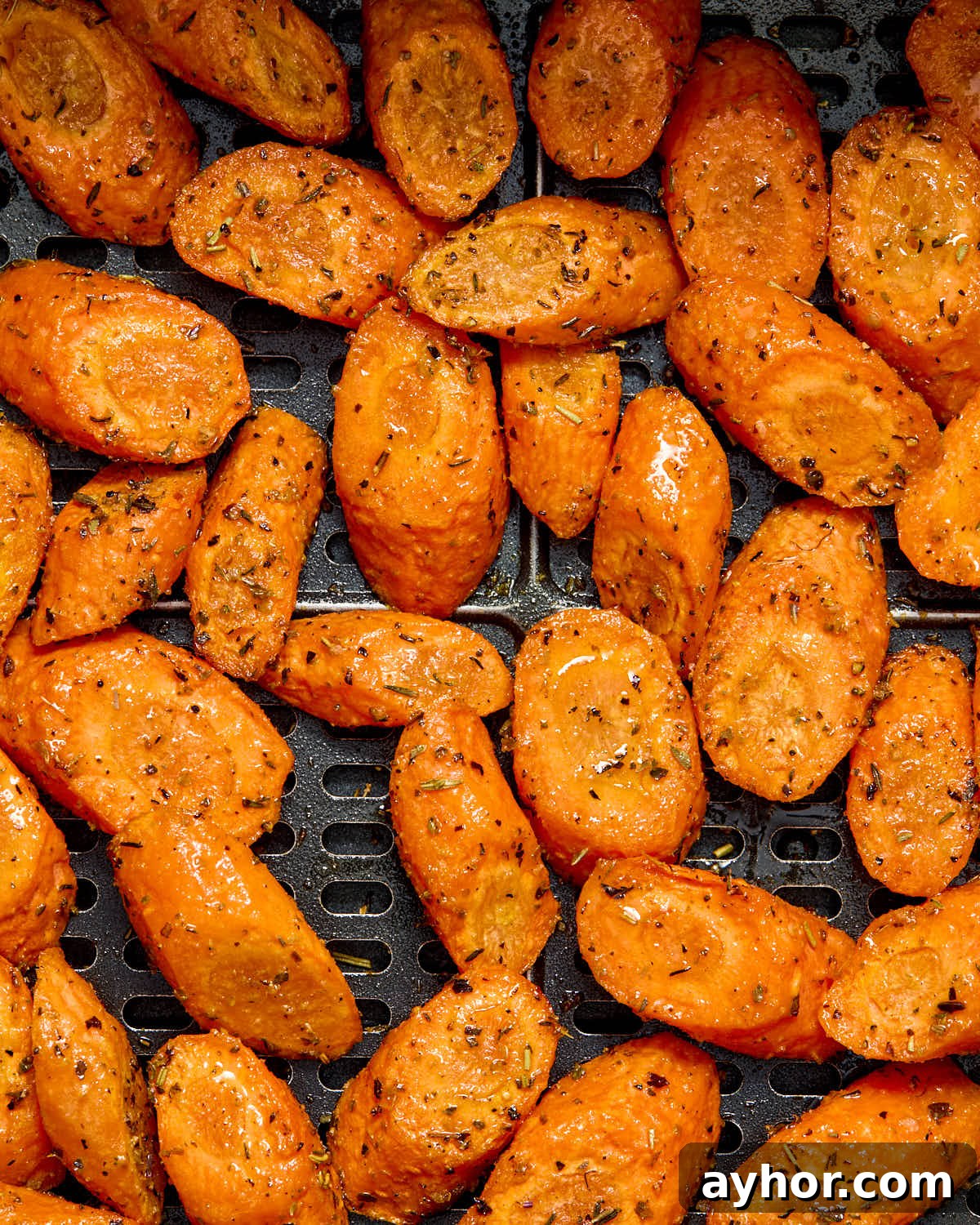 Close up of air fried carrots in the air fryer basket.