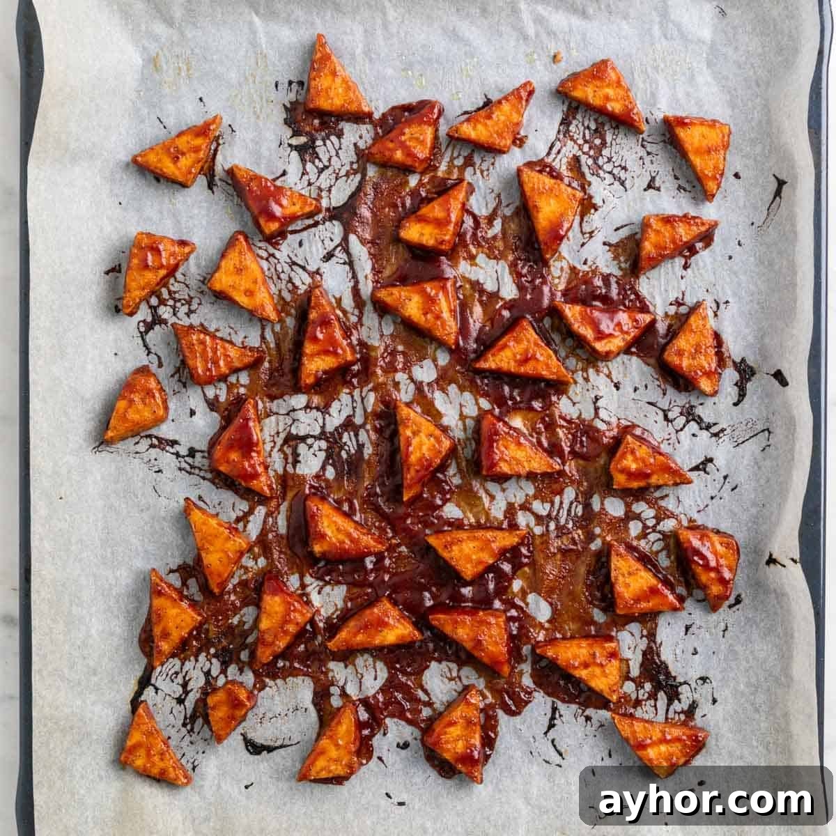 Grilled BBQ Tofu Recipe: Smoky, Glazed Plant-Based Dish 11 Baked BBQ tofu triangles on a baking sheet