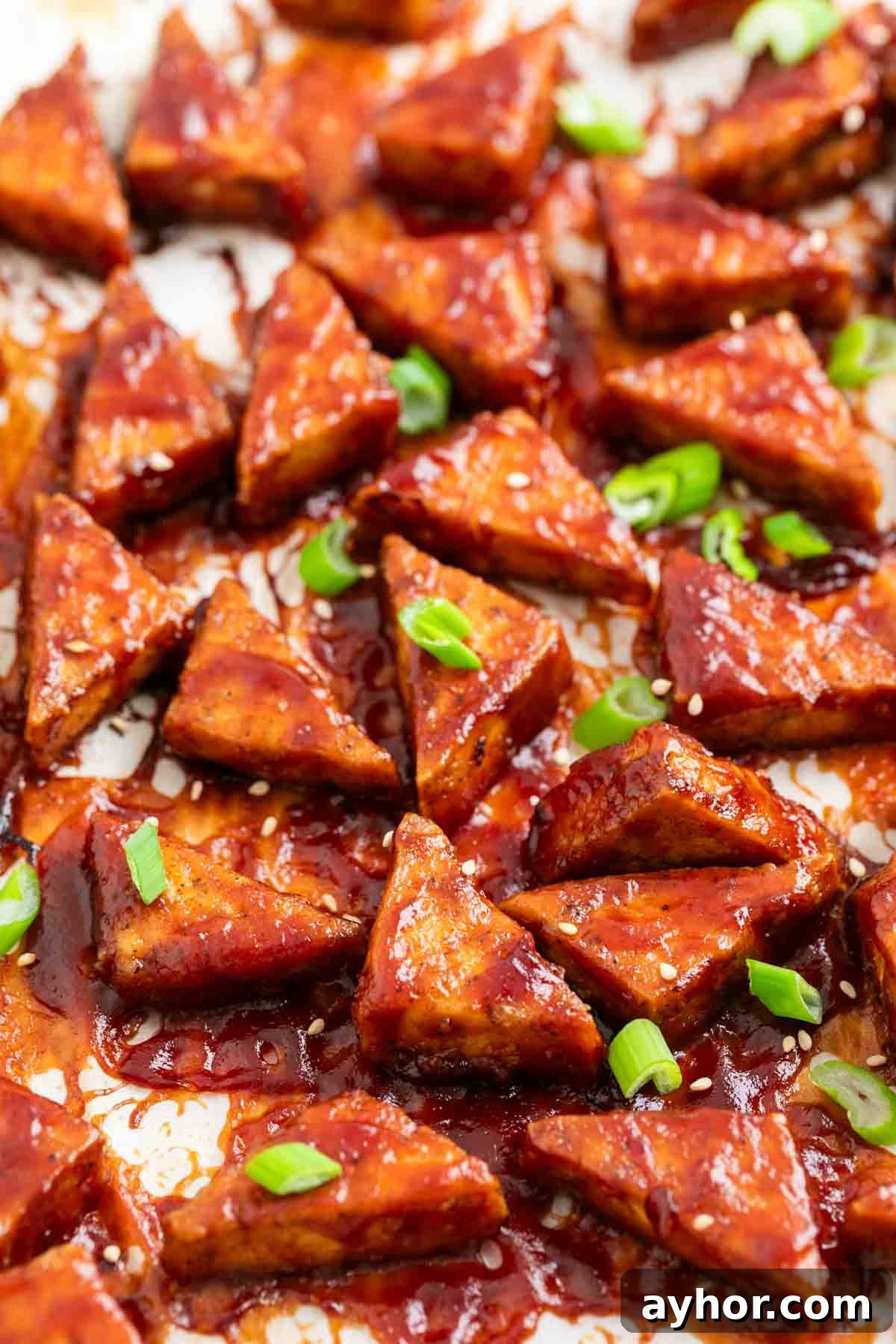 Grilled BBQ Tofu Recipe: Smoky, Glazed Plant-Based Dish 12 Crispy BBQ tofu triangles with sesame seeds and green onions