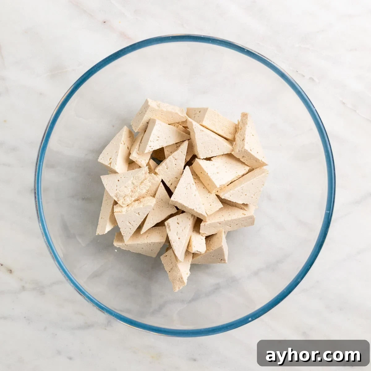 Grilled BBQ Tofu Recipe: Smoky, Glazed Plant-Based Dish 5 Tofu triangles in a mixing bowl