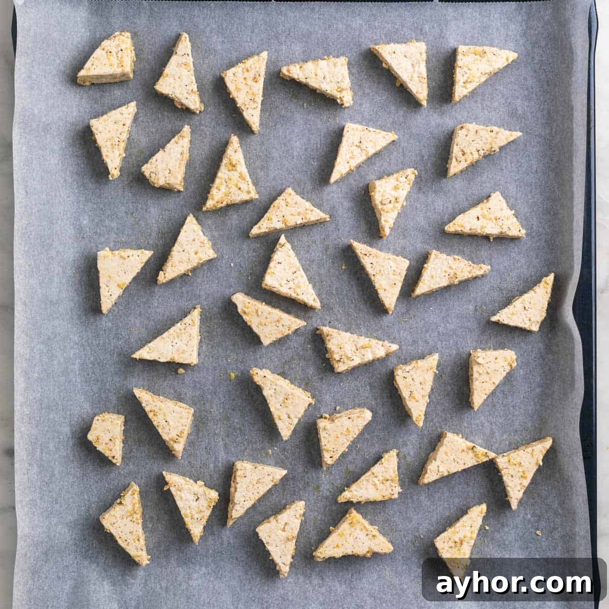 Grilled BBQ Tofu Recipe: Smoky, Glazed Plant-Based Dish 8 Tofu triangles on a baking sheet lined with parchment paper