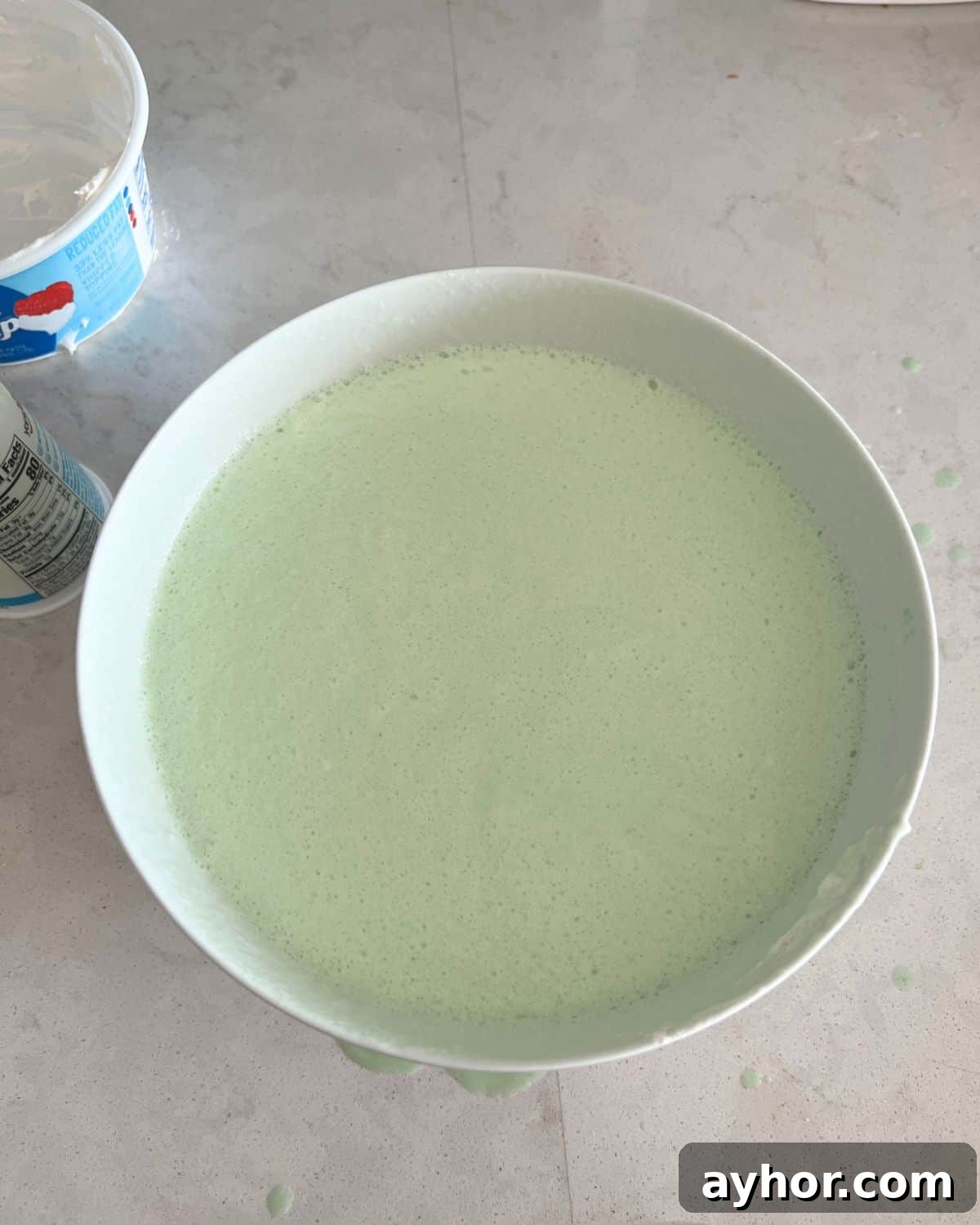 WeightWatchers Key Lime Pie Recipe with Jell-O Twist 5 Yogurt and Cool Whip combined in a bowl with gelatin.