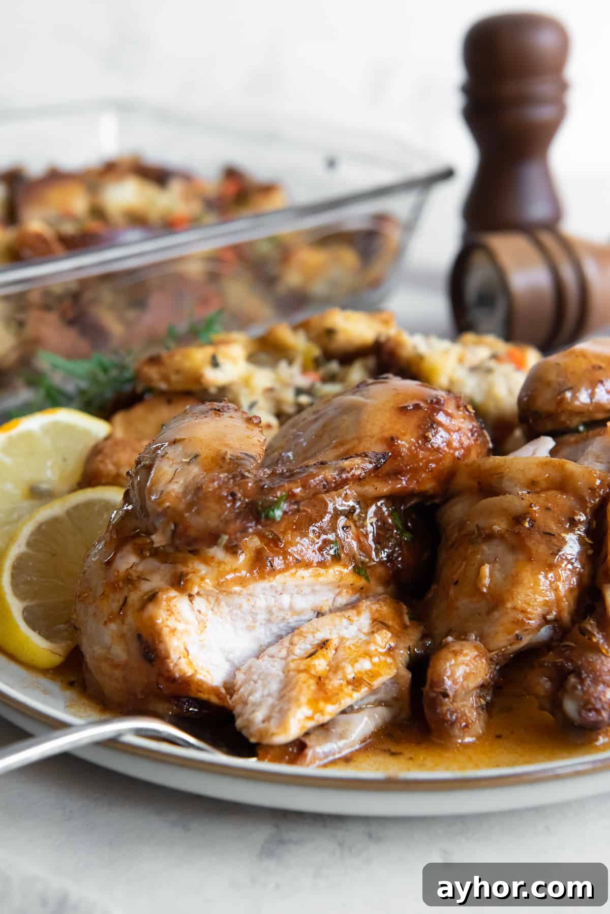 Crispy Roasted Cornish Game Hens with Garlic and Herbs 9 A fork on a plate with a sliced cornish game hen with gravy.