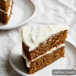 Moist Carrot Cake with Cream Cheese Frosting Recipe 13 Slice of a two layer coconut carrot cake with cream cheese frosting on a plate.