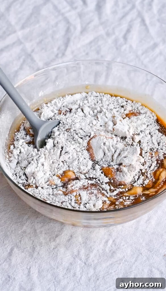 Moist Carrot Cake with Cream Cheese Frosting Recipe 5 Flour and cake batter in a mixing bowl with a silicone spatula.