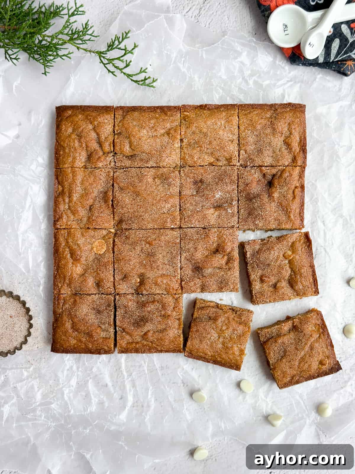 Gingerbread blondies cut into squares with some white chocolate chips around them.