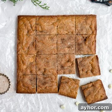 Gingerbread blondies cut into squares with some white chocolate chips around them.