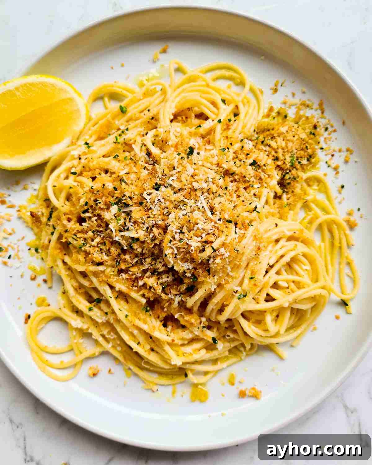 Creamy Lemon Garlic Butter Pasta Recipe for Quick Weeknight Meals 2 Spaghetti topped with breadcrumbs and herbs in a round plate