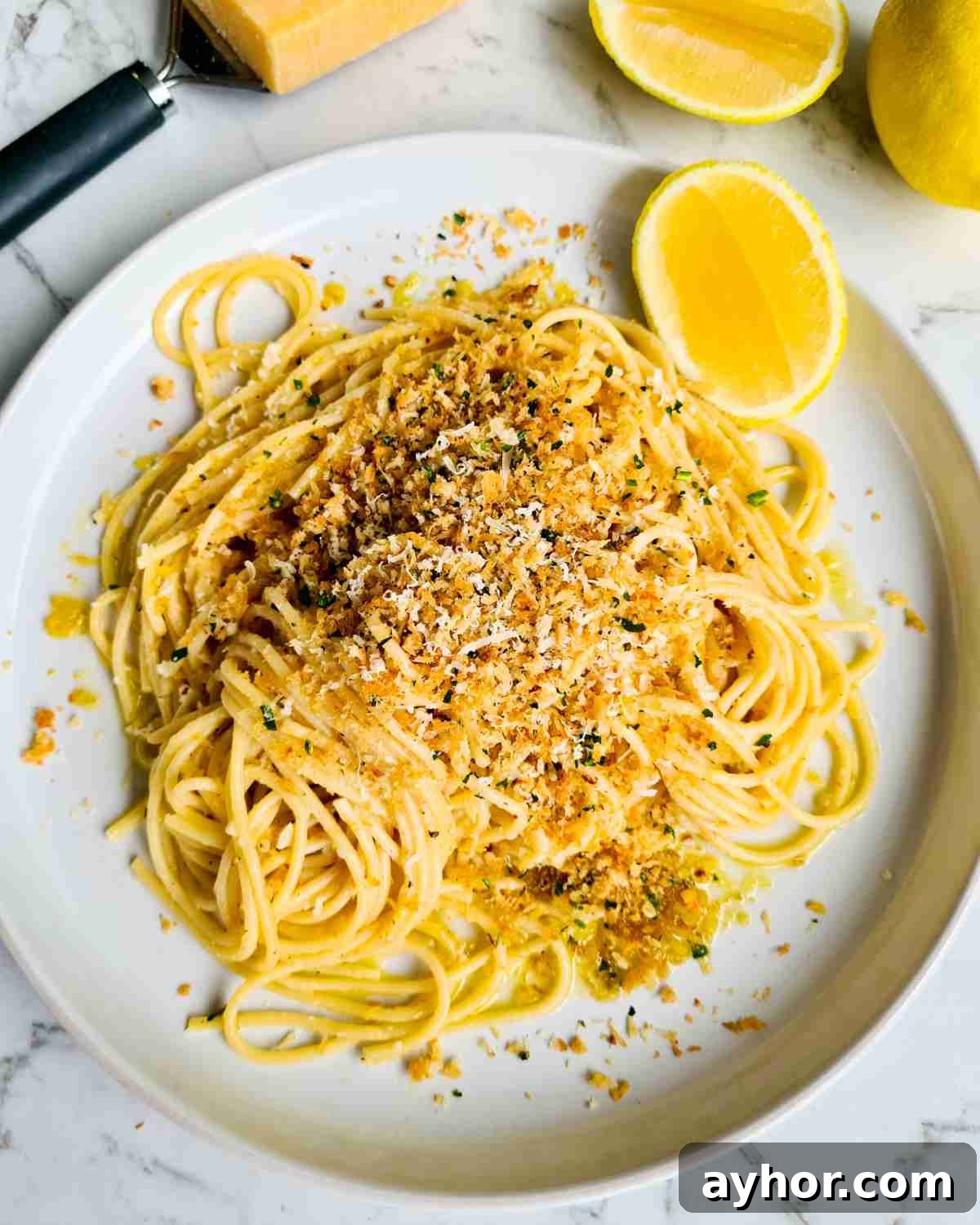 Creamy Lemon Garlic Butter Pasta Recipe for Quick Weeknight Meals 16 Lemon spaghetti topped with herbed breadcrumbs with lemon and parmesan cheese in the background