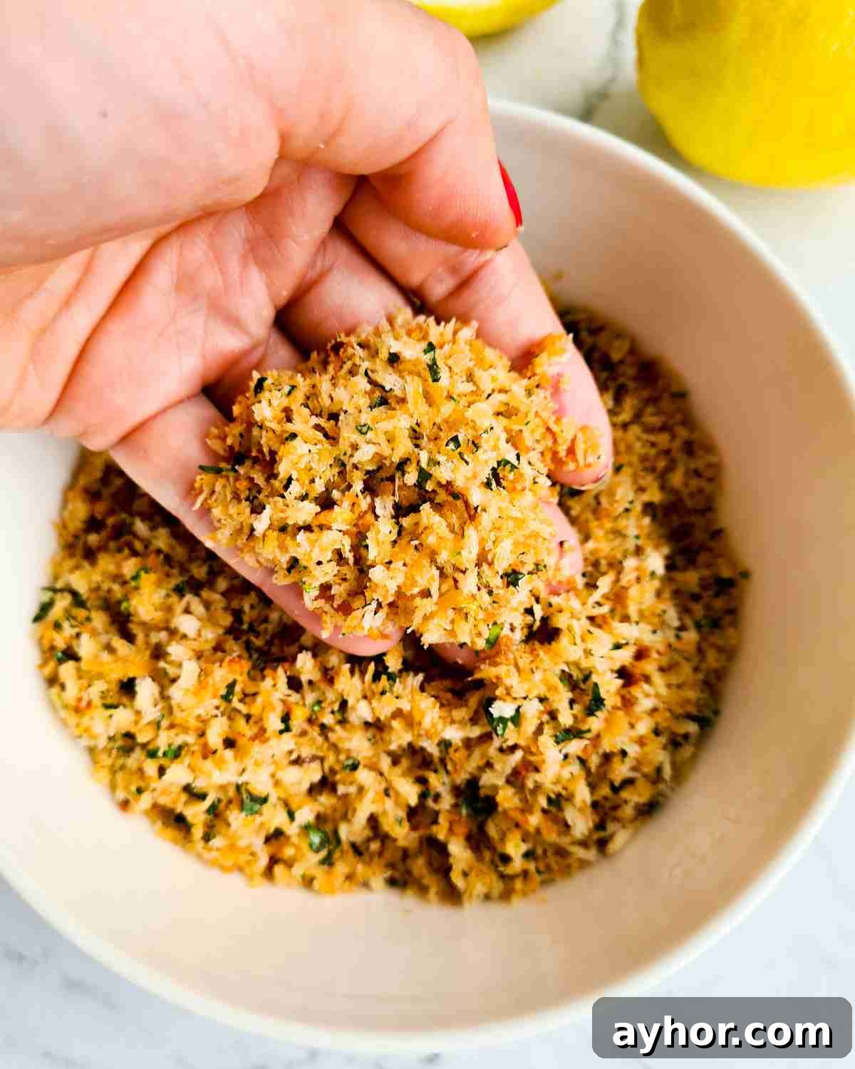 Creamy Lemon Garlic Butter Pasta Recipe for Quick Weeknight Meals 10 Golden herb breadcrumbs being scopped up by a hand over a bowl