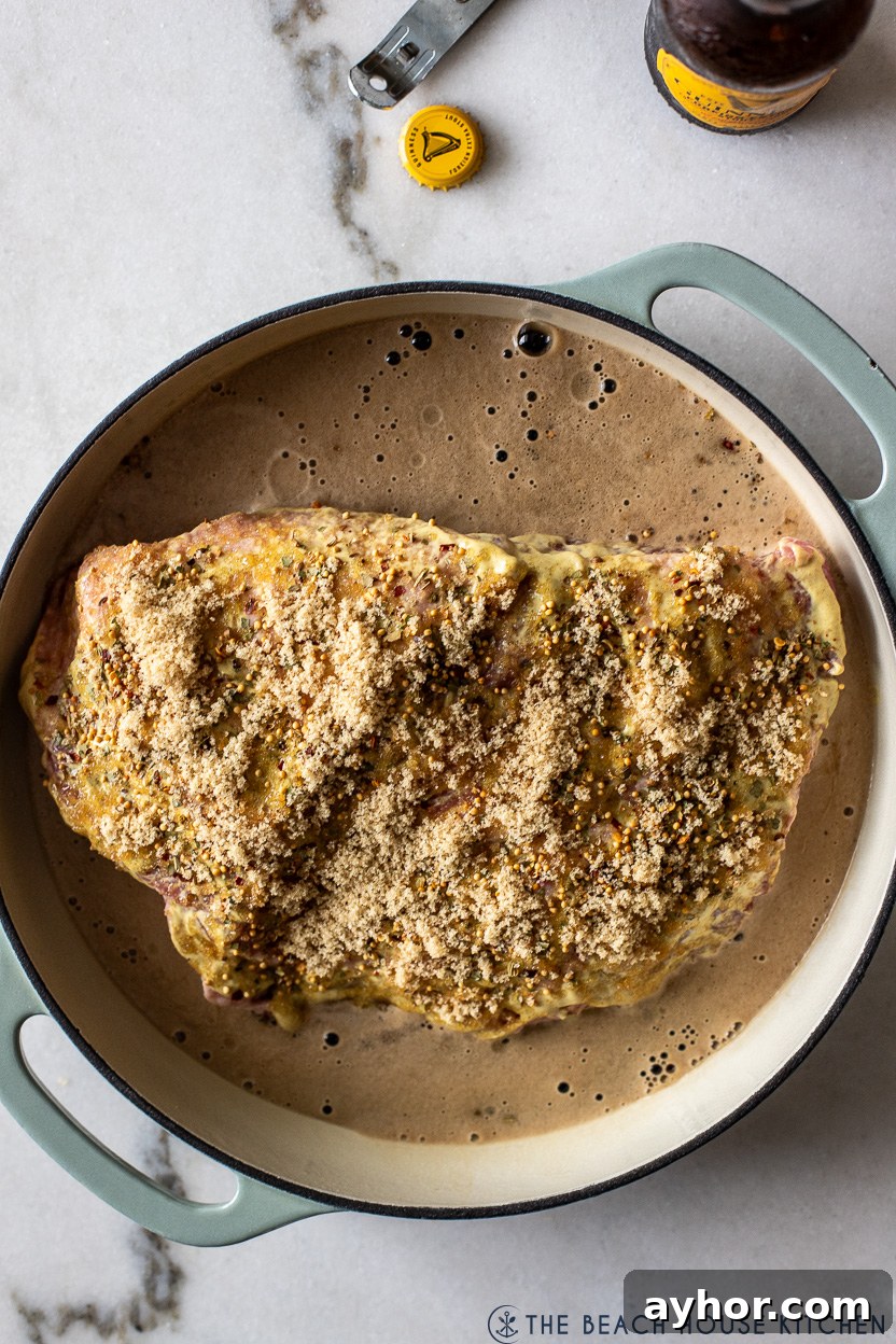 Classic Corned Beef and Cabbage Recipe for St. Patrick's Day 6 Overhead photo of cast iron dish filled with a pre-baked corned beef brisket with Guinness