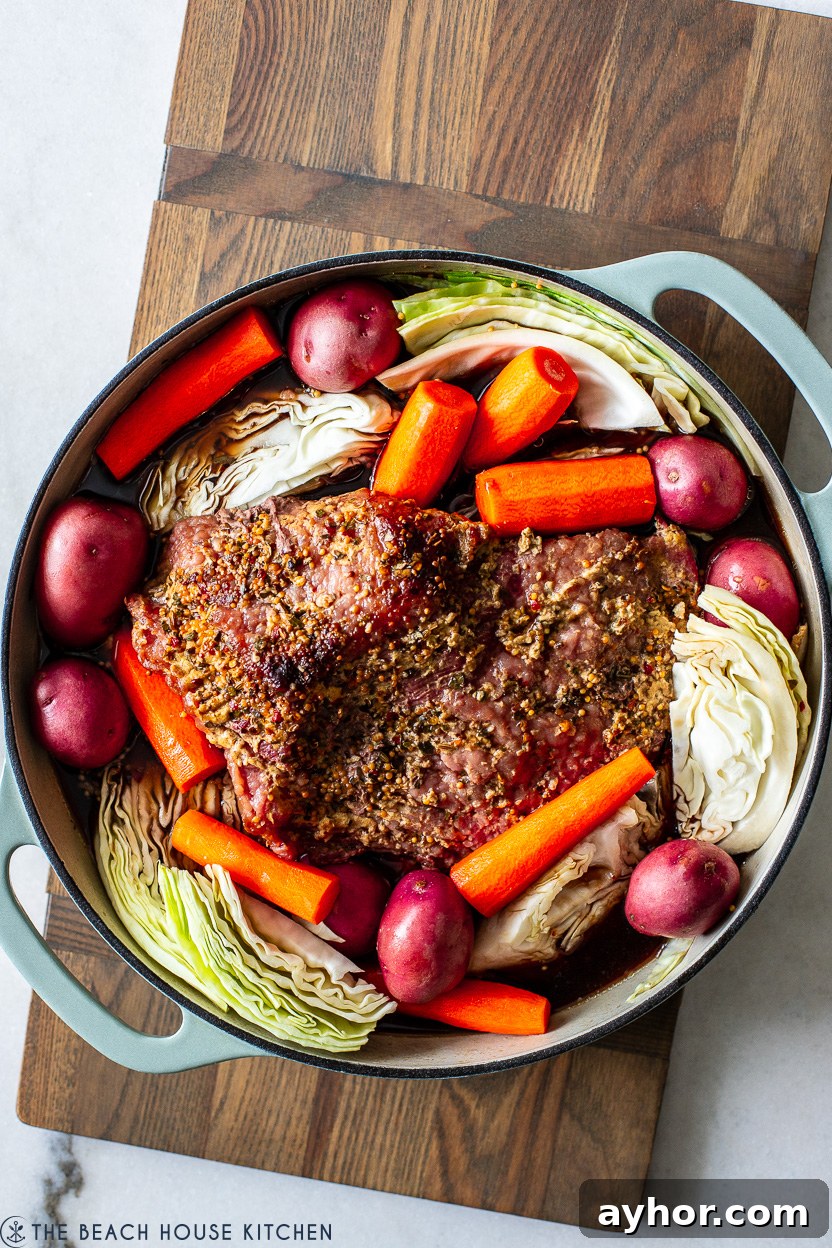 Classic Corned Beef and Cabbage Recipe for St. Patrick's Day 7 Overhead photo of a cooked corned beef brisket surrounded by potatoes, carrots and cabbage