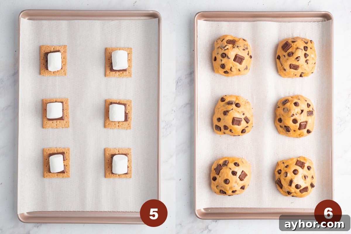 Ultimate S'mores Cookie Recipe: Crispy Edges & Gooey Centers 5 Fix graham crackers are spaced on a lined baking sheet. A piece of a chocolate bar and a large marshmallow sits on top of the graham crackers. Then the cookie batter is piled on top.