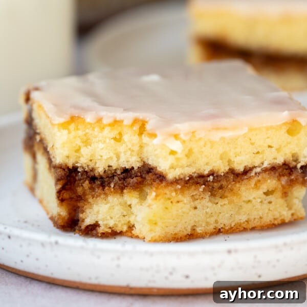 Ultimate S'mores Cookie Recipe: Crispy Edges & Gooey Centers 8 A slice of honey bun cake with a bite taken out of it sitting on a white plate.