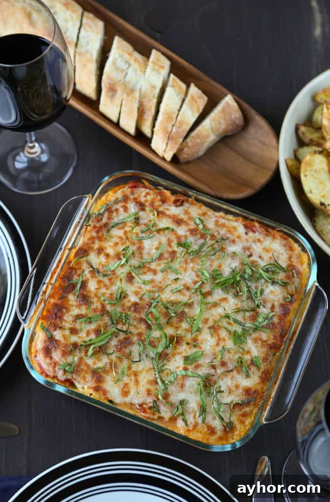 Spaghetti Squash Lasagna Recipe: Low-Carb Cheesy Layered Bake 5 spaghetti squash lasagna on a dinner table with plates and sliced french bread.