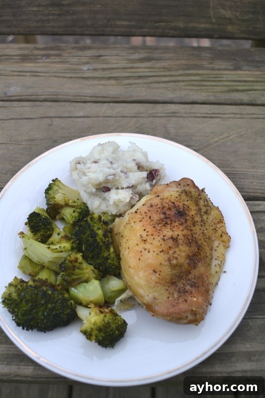 Roast chicken on white plate with broccoli and mashed potatoes