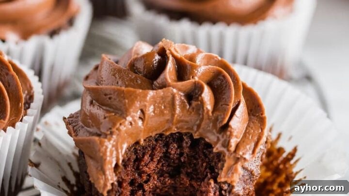 a paleo chocolate cupcake with chocolate frosting, with a bite taken out