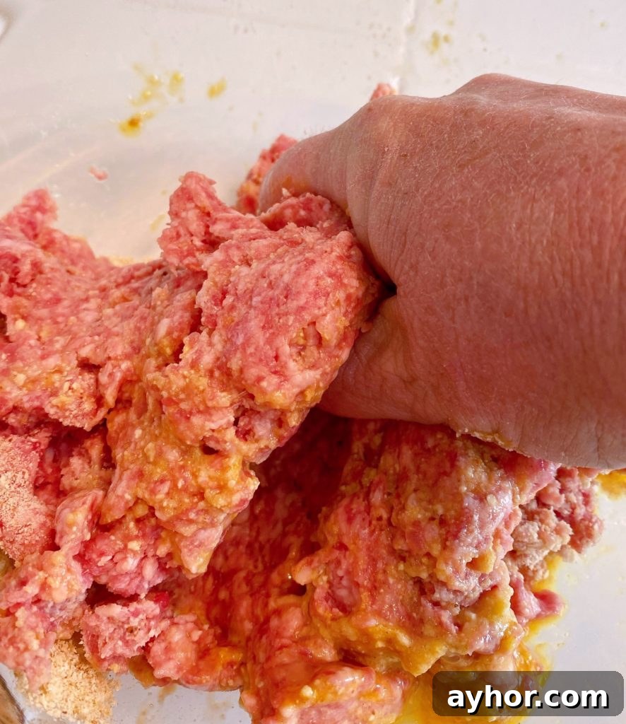 Mixing meatball ingredients with hands to combine all the ingredients.