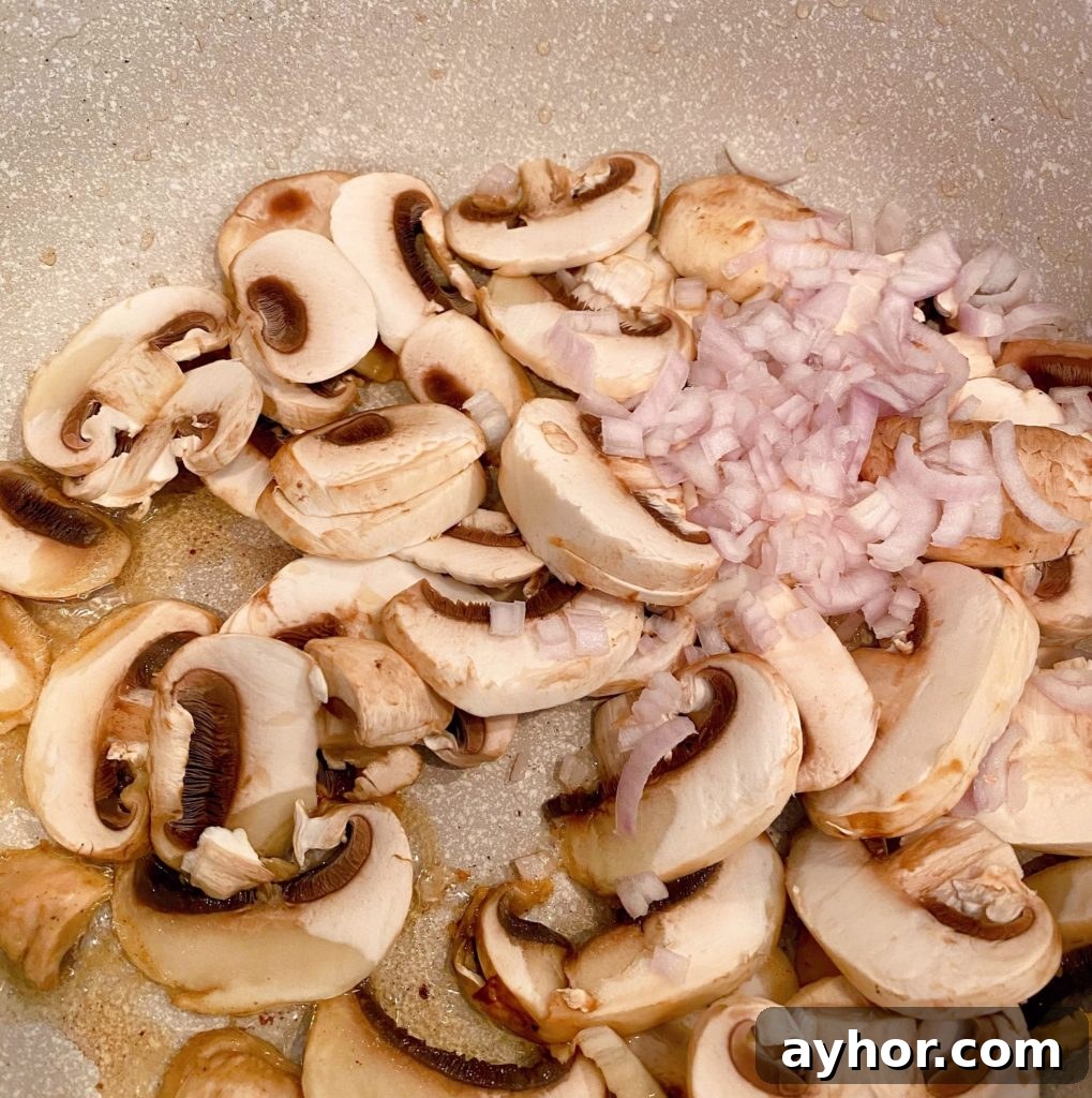 Sliced mushrooms and scallion in pan.
