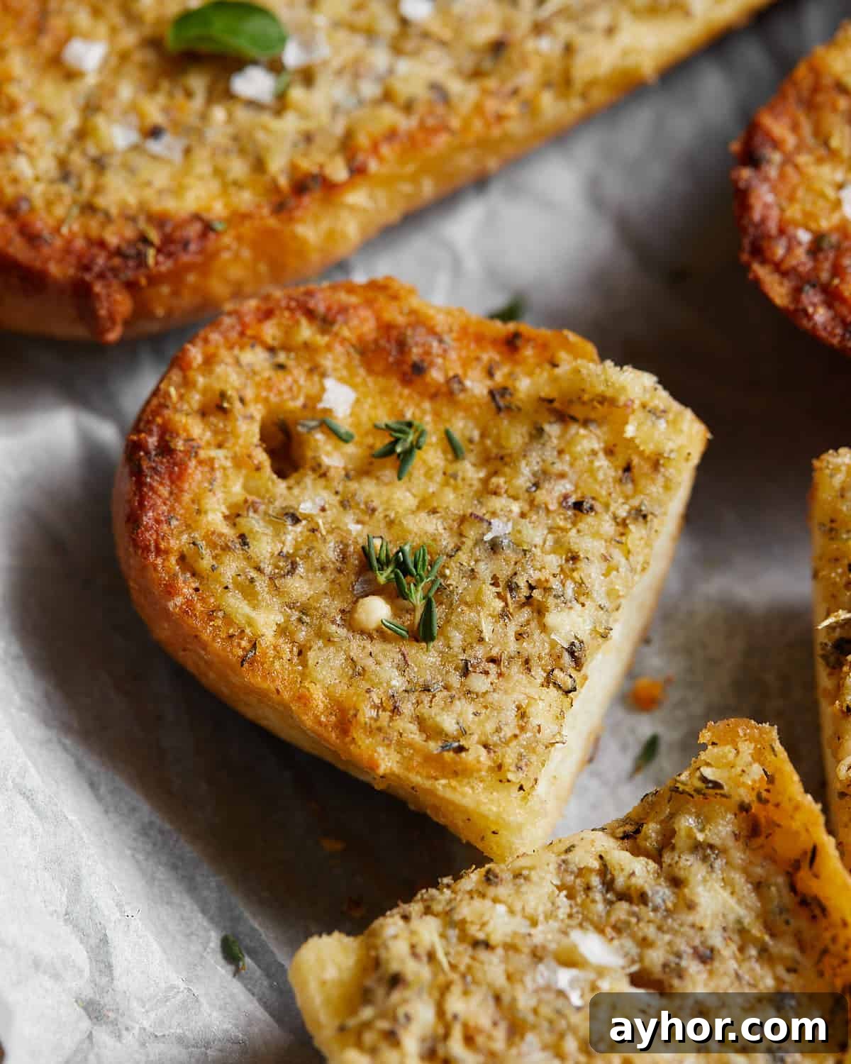 Up close image of garlic bread spread with garnish.