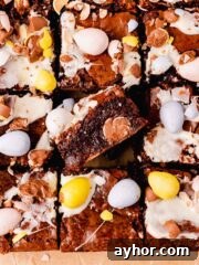 brownies topped and filled with mini eggs on parchment paper