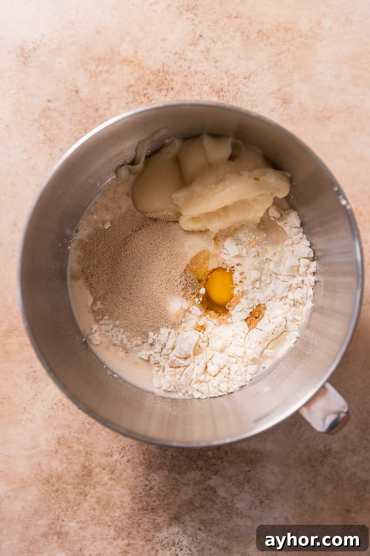 Cinnabon-Style Cinnamon Roll Cake Recipe 4 Cinnamon roll ingredients in a mixing bowl before kneading.