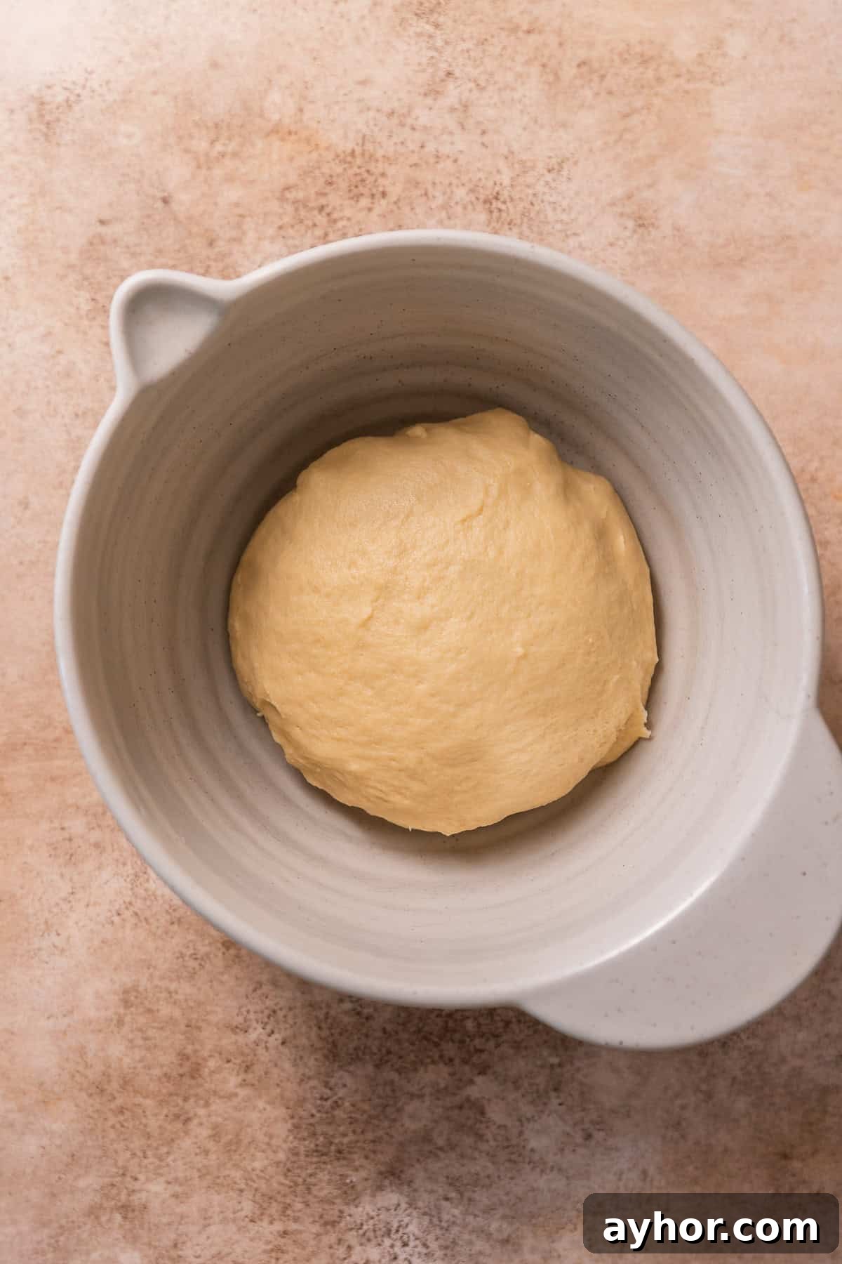 Cinnabon-Style Cinnamon Roll Cake Recipe 6 The cinnamon roll dough in a bowl, resting.