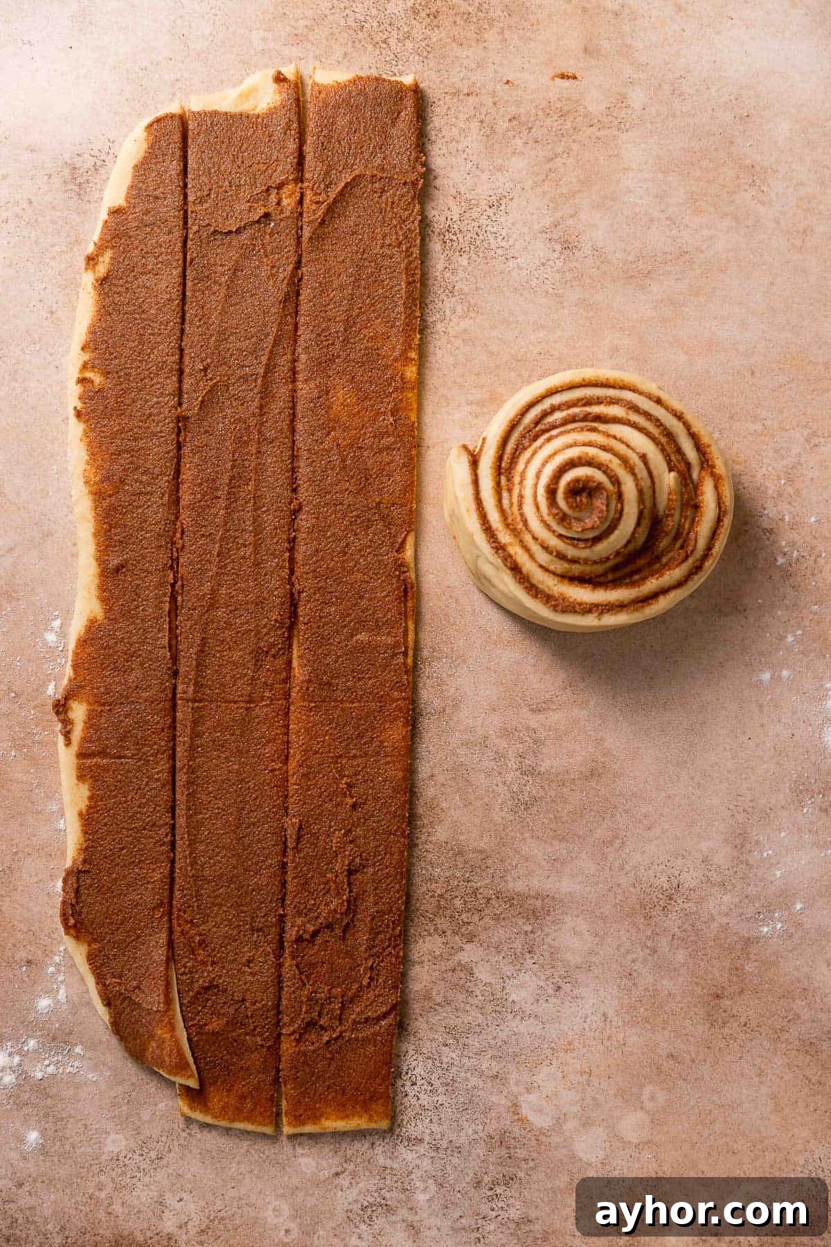 Cinnabon-Style Cinnamon Roll Cake Recipe 8 The strips of cinnamon sugar dough being rolled up together into one giant bun.