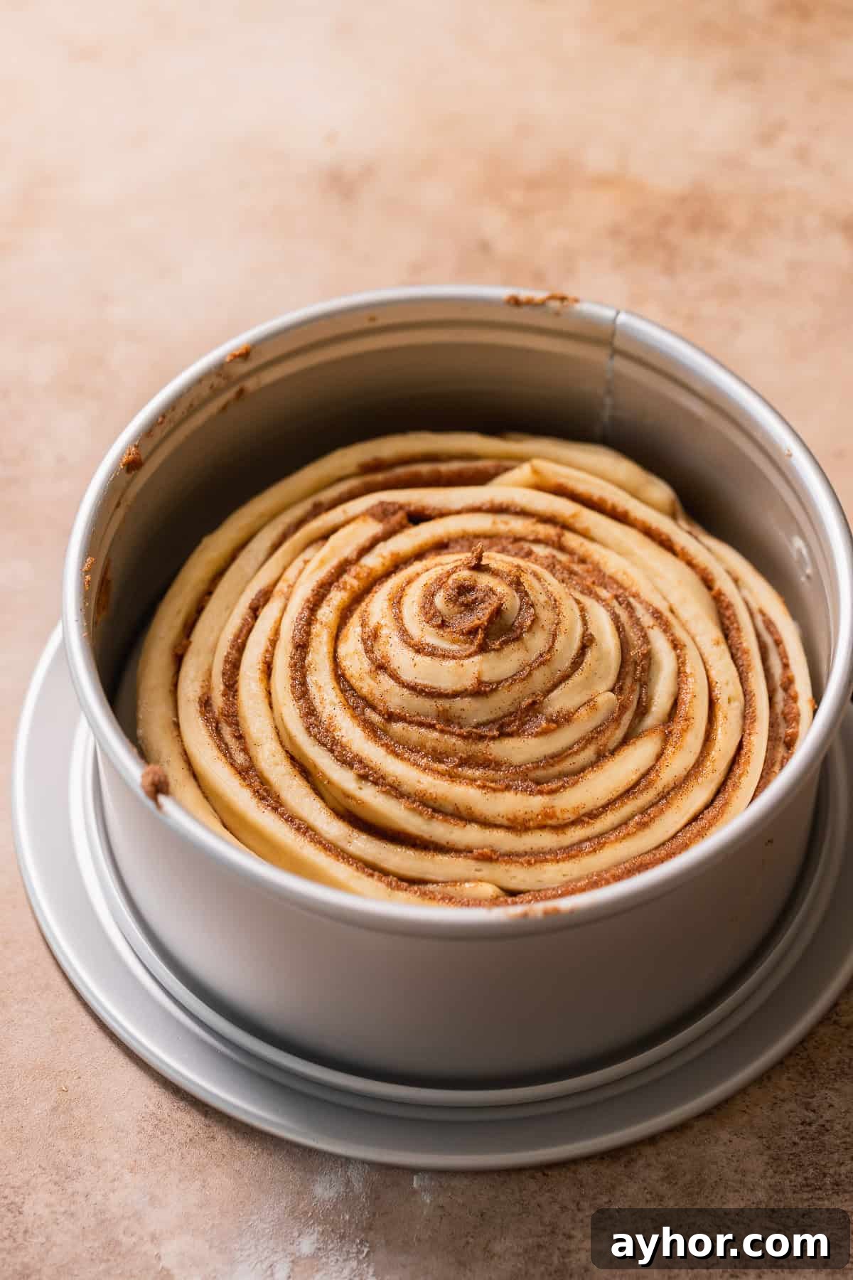 Cinnabon-Style Cinnamon Roll Cake Recipe 9 The giant cinnamon bun in a cake pan.