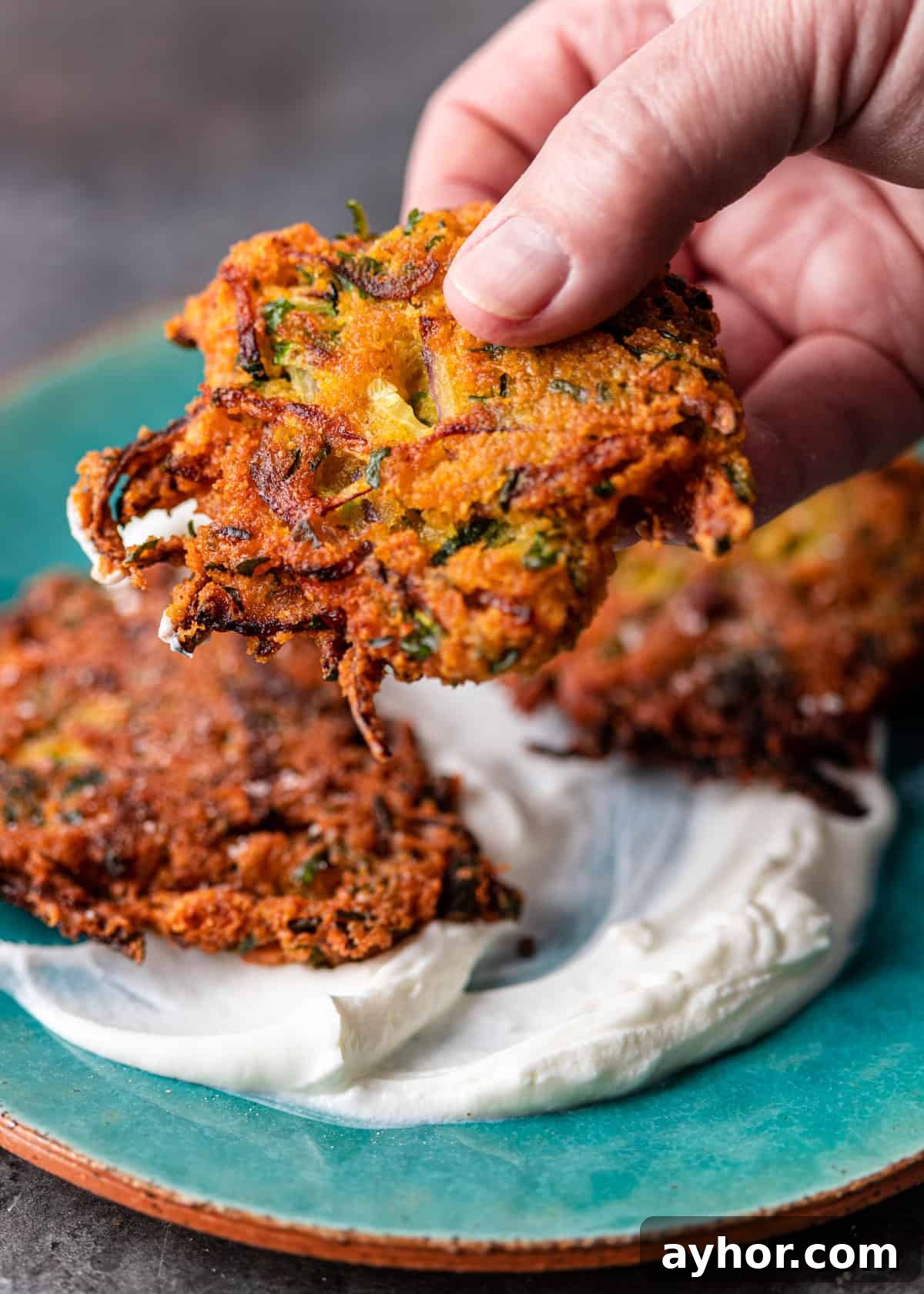 Crispy Zucchini and Lentil Fritters 9 closeup side view: zucchini lentil fritter and yogurt