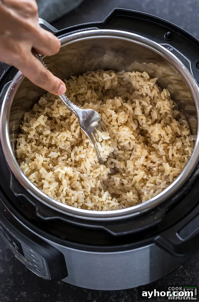 Fluffy Instant Pot Brown Rice in 20 Minutes 9 instant pot brown rice being fluffed with a fork