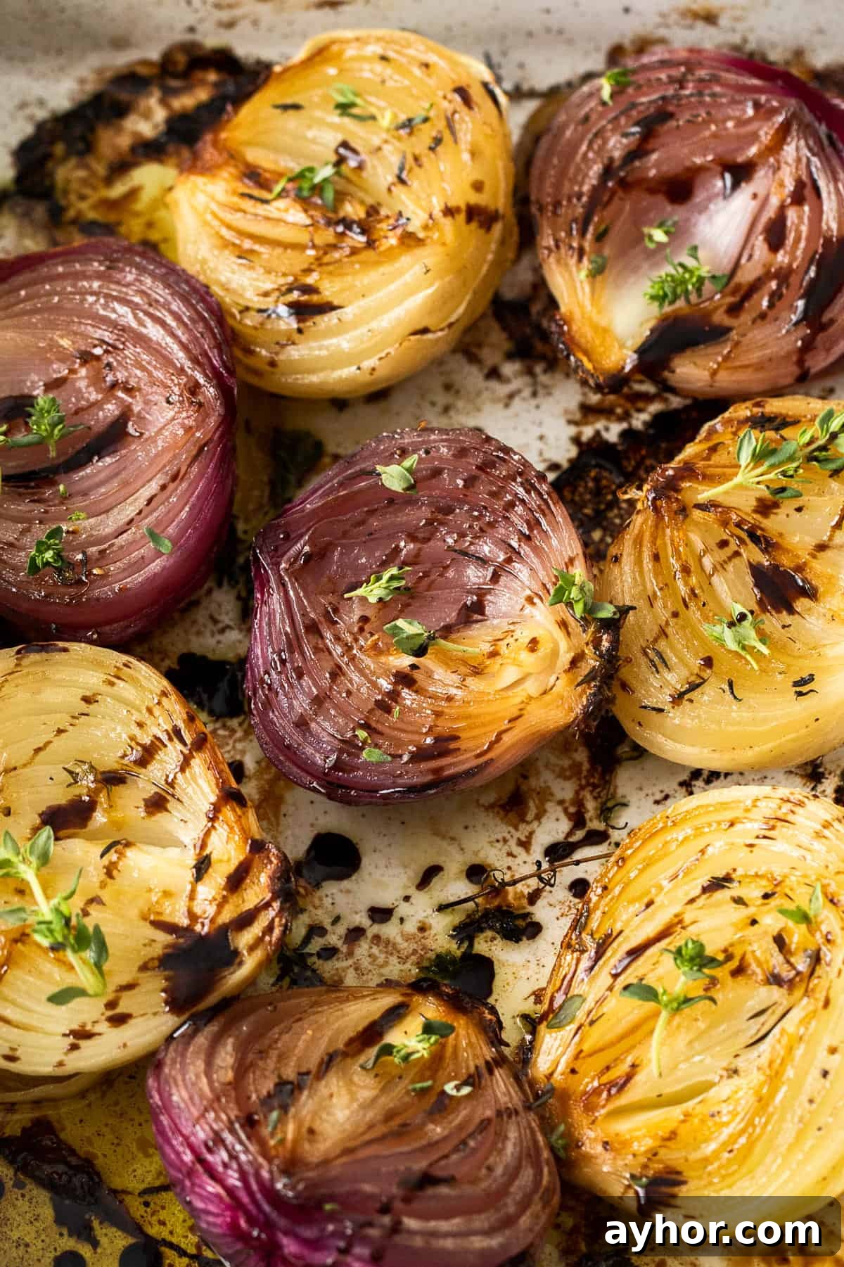 Roasted onions garnished with some fresh thyme leaves and drizzled with balsamic glaze.