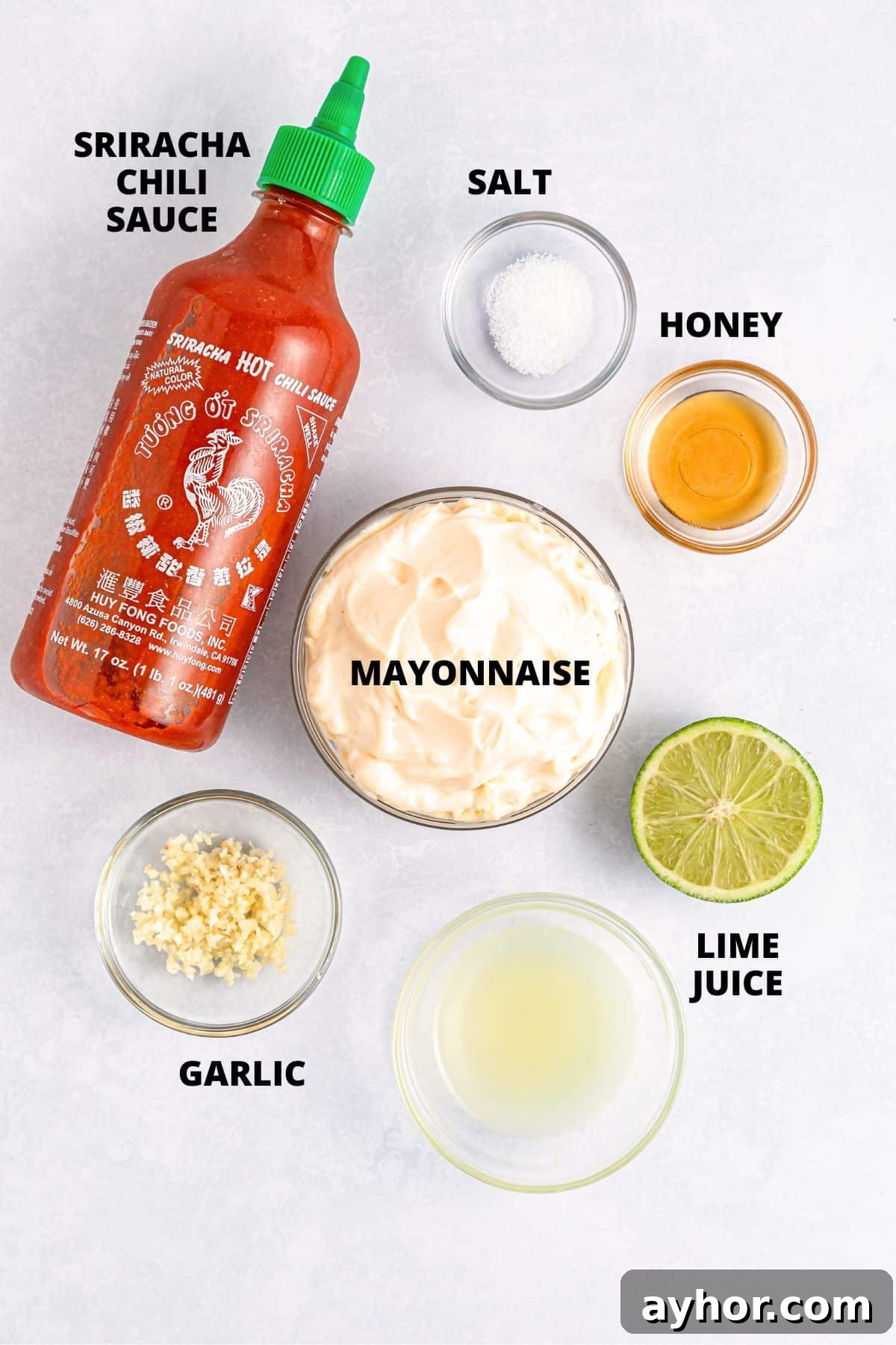 Sriracha Aioli Recipe (Gluten-Free, Dairy-Free) Ingredients for sriracha aioli recipe laid out on white board.