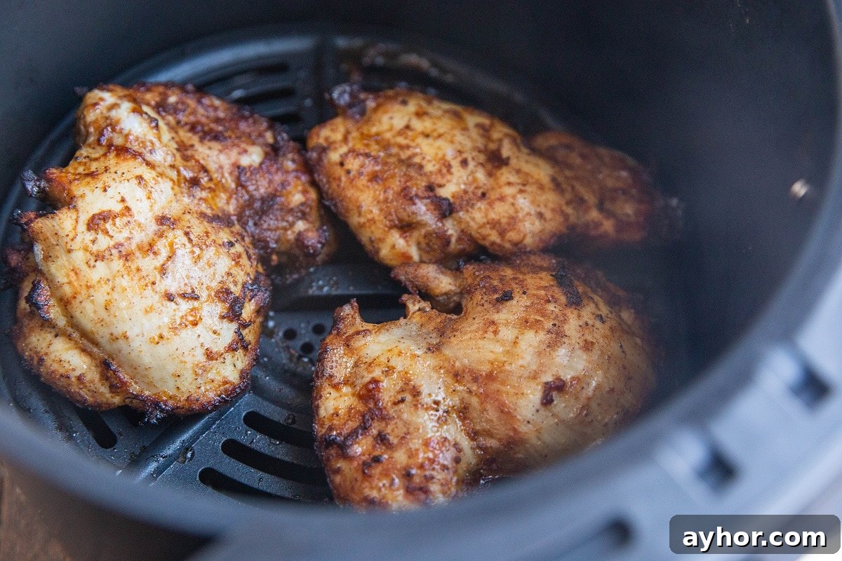 Crispy Mediterranean Chicken Thighs in the Air Fryer 9 Cooked chicken thighs in an air fryer.