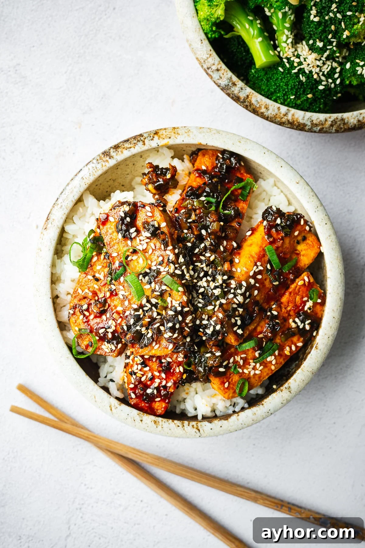 Gochujang Braised Tofu: Spicy Korean Tofu Recipe 7 Korean braised tofu on white rice with a side of sesame broccoli.