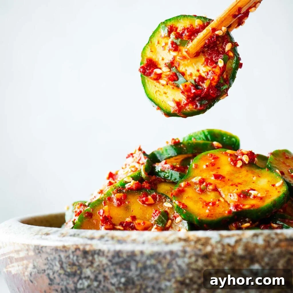 Gochujang Braised Tofu: Spicy Korean Tofu Recipe 9 A serving of Korean spicy cucumber salad being enjoyed with chopsticks.