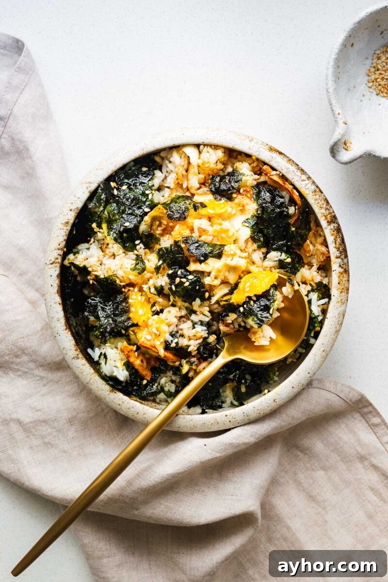Gochujang Braised Tofu: Spicy Korean Tofu Recipe 10 A bowl of gyeran bap with everything mixed together using a golden spoon.