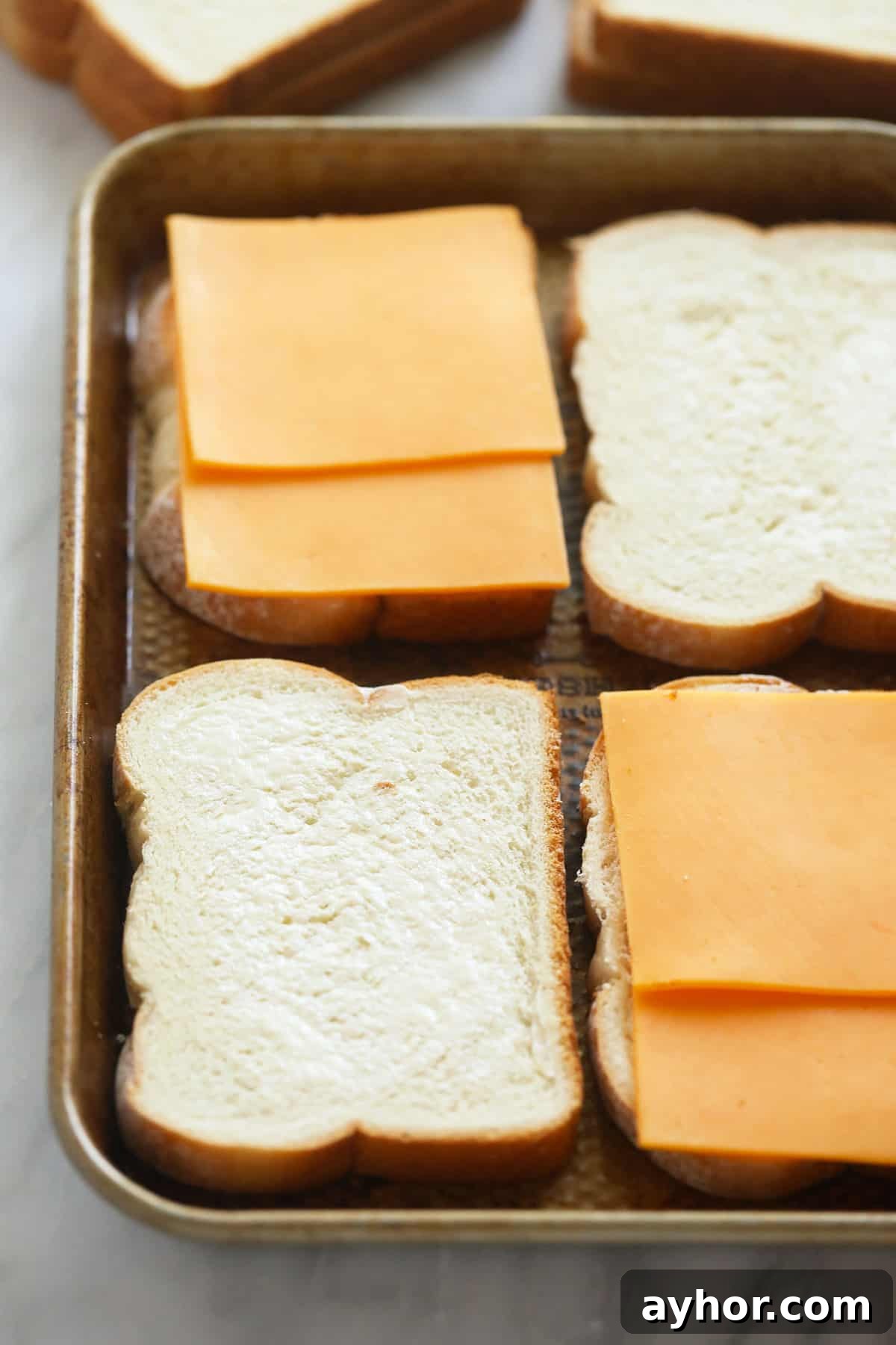 Assembling on a sheet pan sheet pan grilled cheese sandwiches being assembled on a sheet pan before being baked