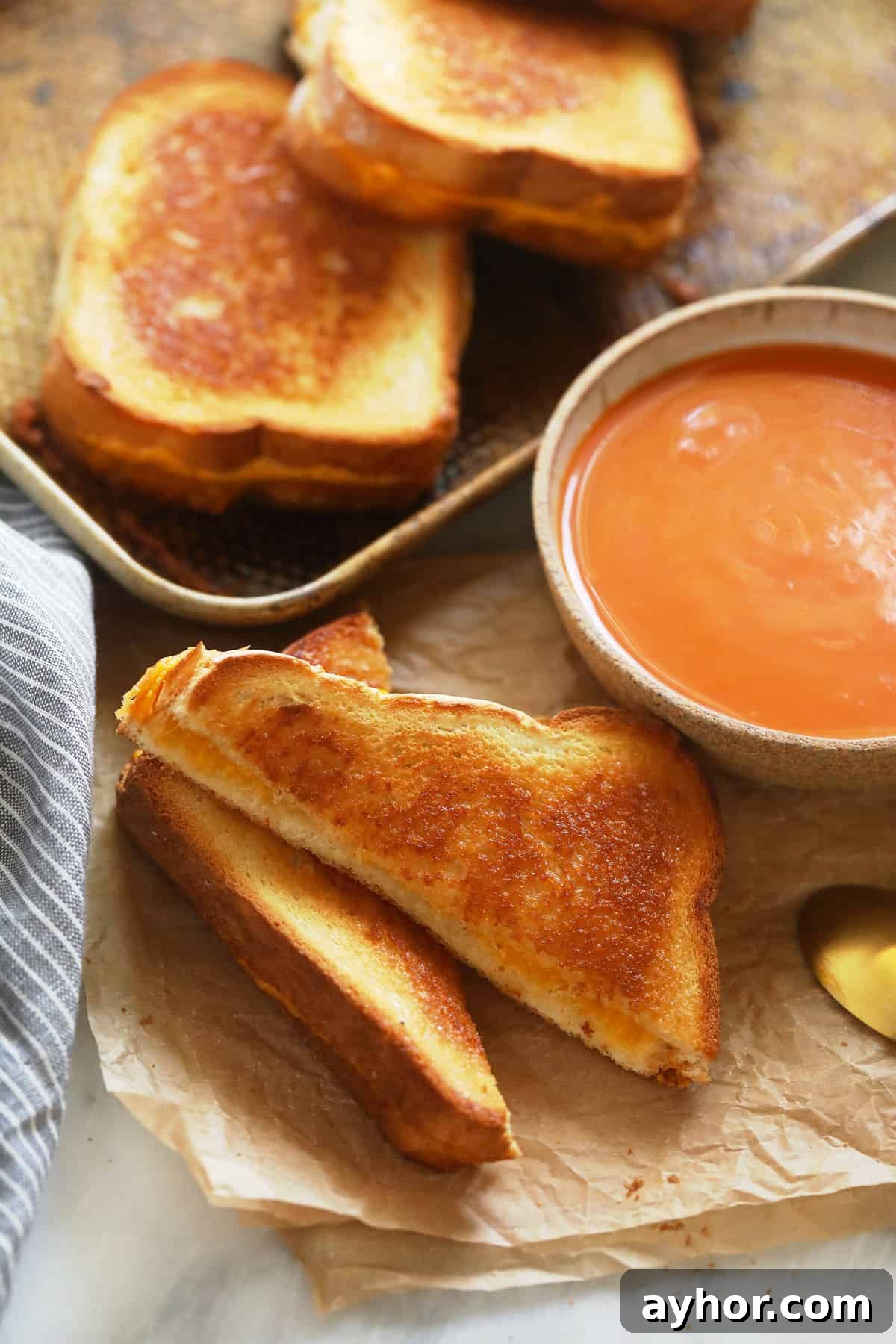 Grilled cheese with tomato soup sheet pan grilled cheese sandwiches next to a bowl of tomato soup